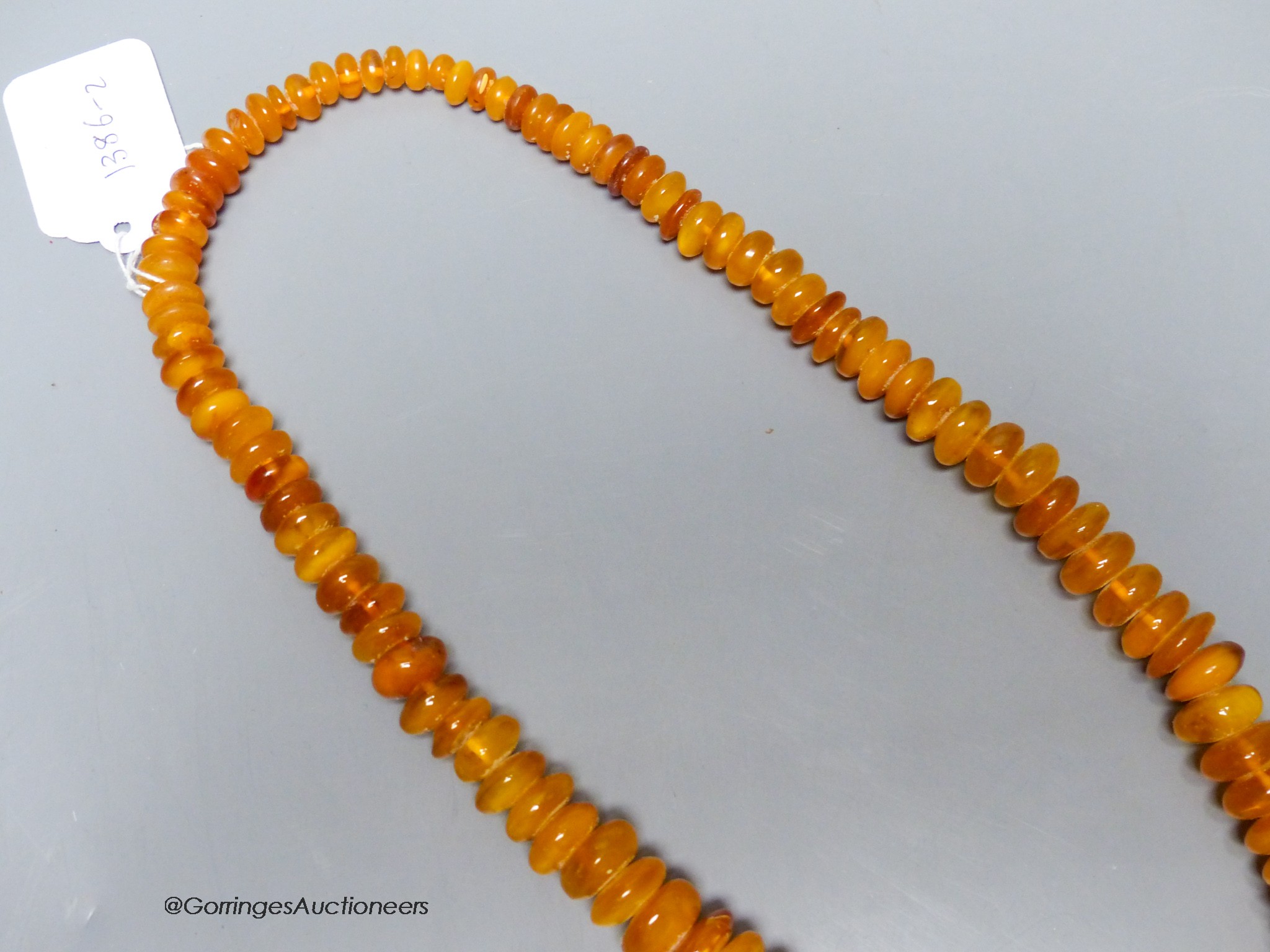 A single strand amber disc necklace, 67cm, gross weight 127 grams.